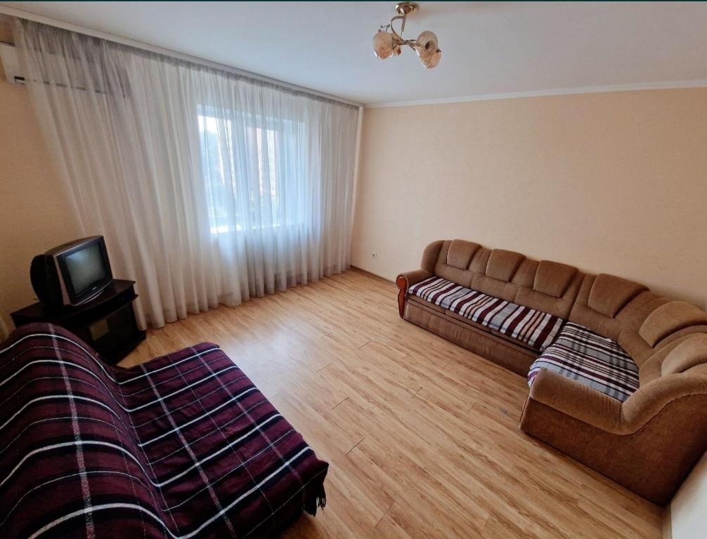 a living room with a couch and a tv at Apartment on Kravchuka, 11b in Lutsk