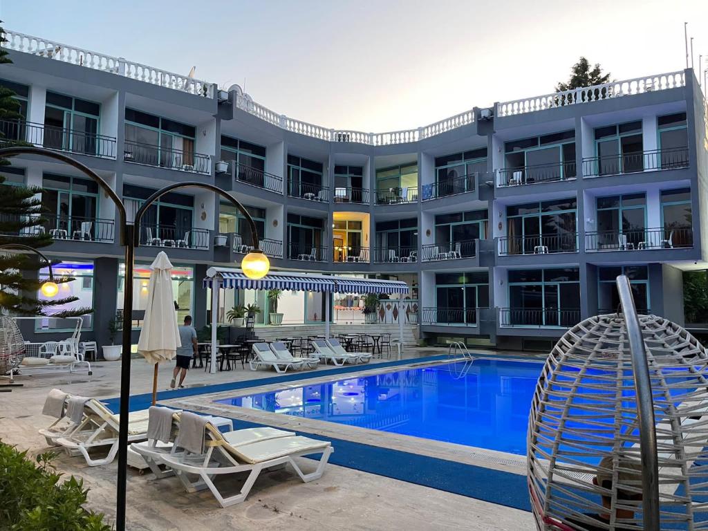 un hotel con piscina e sedie e un edificio di MODA SUİT ÇAMYUVA a Antalya (Adalia)