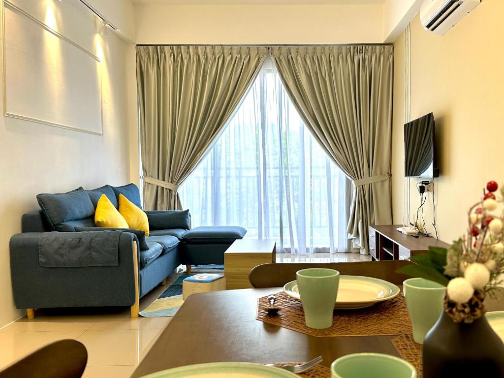uma sala de estar com um sofá azul e uma mesa em Ipoh Luxurious Homestay by Comfort Home em Ipoh