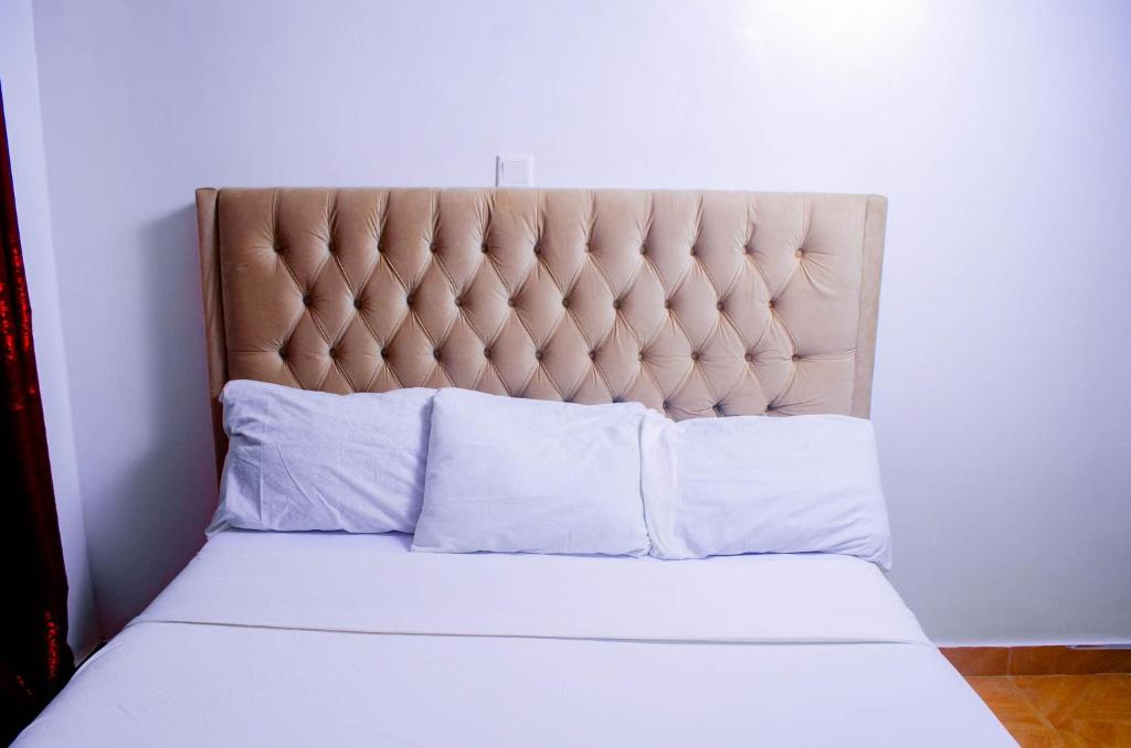a bed with white sheets and pillows in a room at Buvan homes in Eldoret