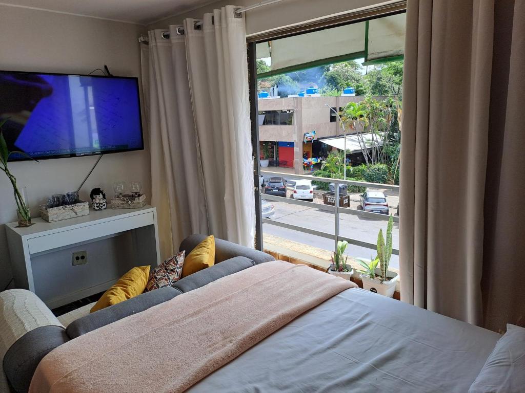 un salon avec un canapé et une grande fenêtre dans l'établissement LOFT Adorável no coração de BsB, à Brasilia