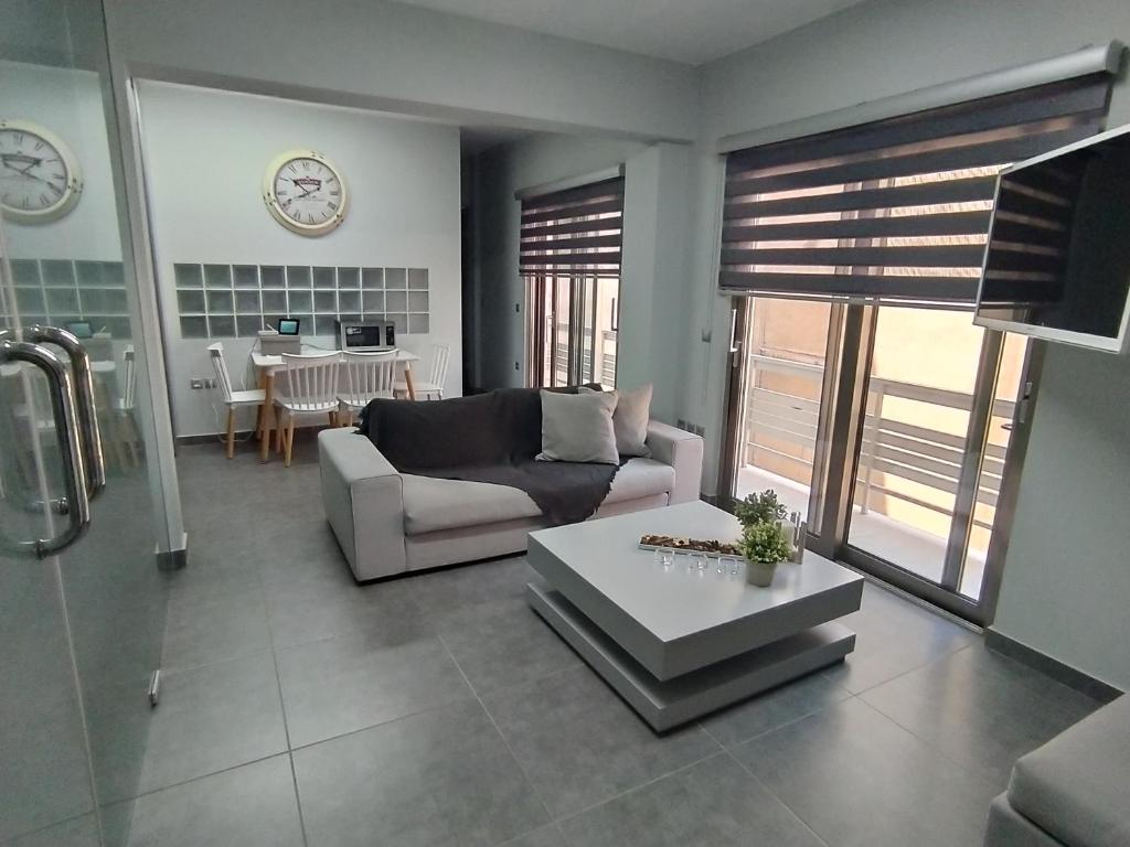 uma sala de estar com um sofá e uma mesa em Academys Modern Apartment by Aesthetic & Luxurious em Atenas