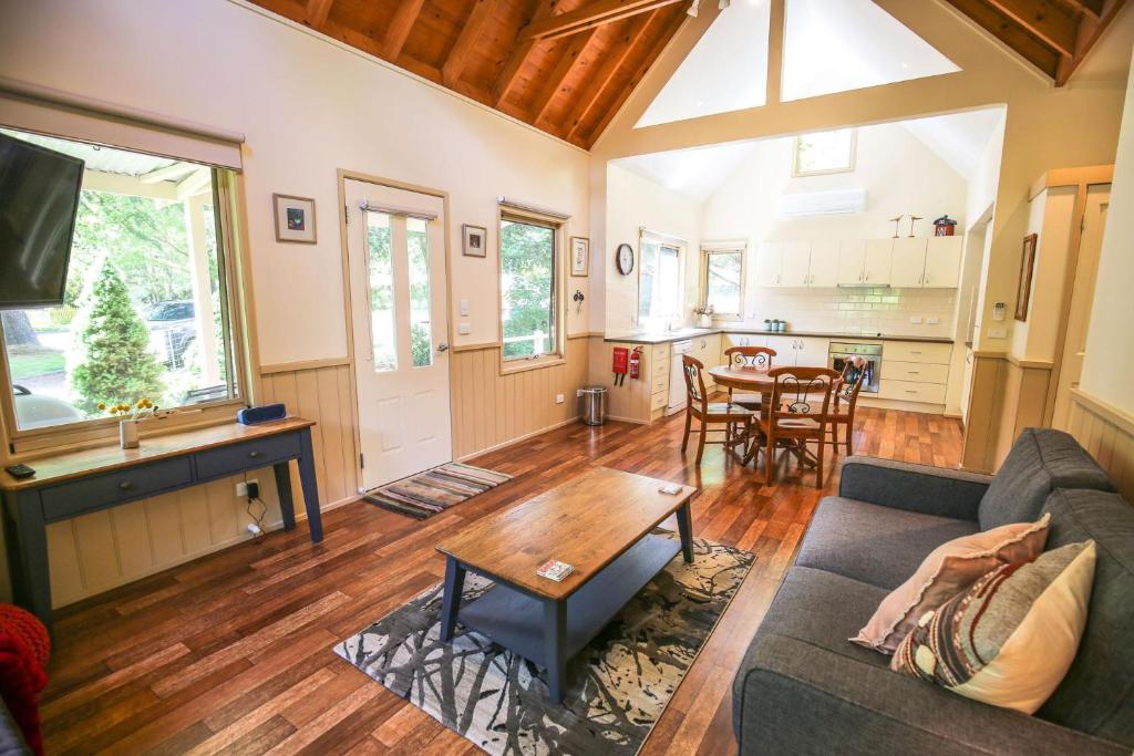 ein Wohnzimmer mit Sofa und Tisch in der Unterkunft Alpine Arnica Cottage 1 in Harrietville
