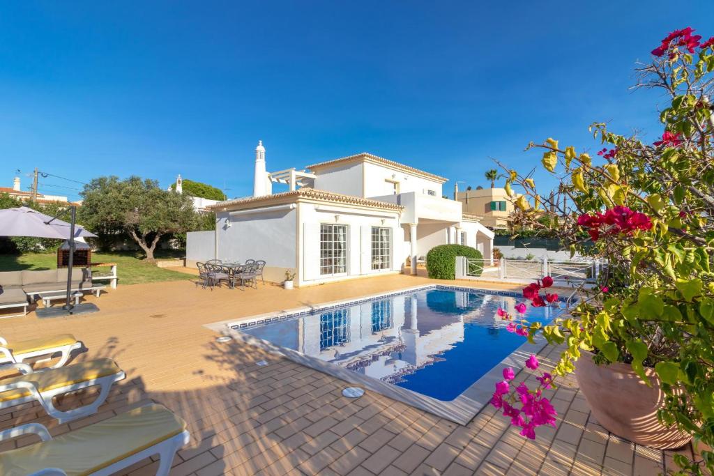 a villa with a swimming pool in front of a house at Casa Anton in Carvoeiro