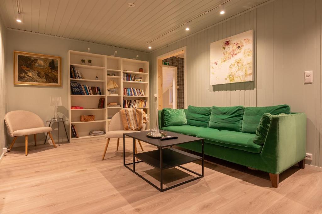 a living room with a green couch and a table at Urban and stylish apartment in city centre in Tromsø
