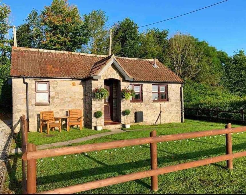 a small stone house with a wooden fence at Cosy & Characterful, Seaside Cottage, Dog Friendly in Worle