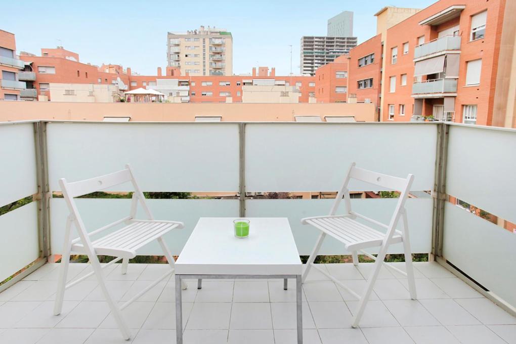 2 Stühle und ein Tisch auf einem Balkon mit Aussicht in der Unterkunft 1223 - POBLENOU APARTMENT in Barcelona