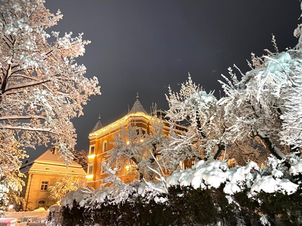 a building with snow covered trees in front of it at InnsbruckHomes at Botanical Garden in Innsbruck