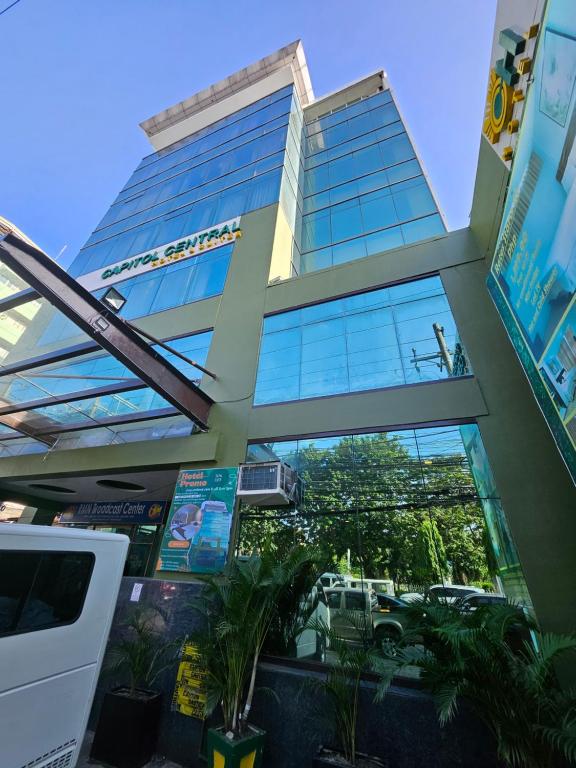 a tall glass building with a truck in front of it at Cebu Capitol Central Hotel & Suites powered by Cocotel in Cebu City