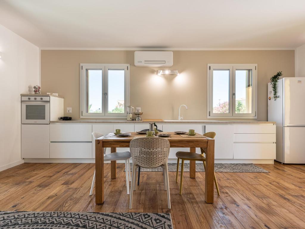 een keuken met een tafel en stoelen en een koelkast bij Villa Mika in Capitana