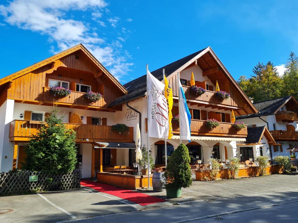 ein Hotel mit Flaggen vor einem Gebäude in der Unterkunft Hotel Nuss in Grainau