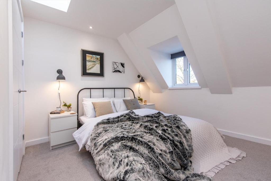 a white bedroom with a bed and a window at Your Northampton Apartments Haven in Northampton