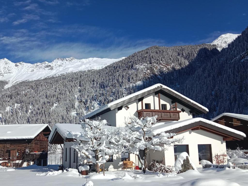 a building in the snow with a mountain at Landhaus St. Hubertus in Kaunertal