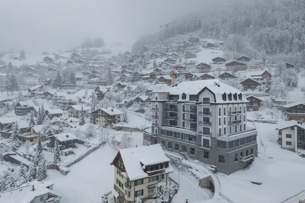 una ciudad cubierta de nieve con casas y edificios en Swiss Hotel Apartments - Engelberg, en Engelberg