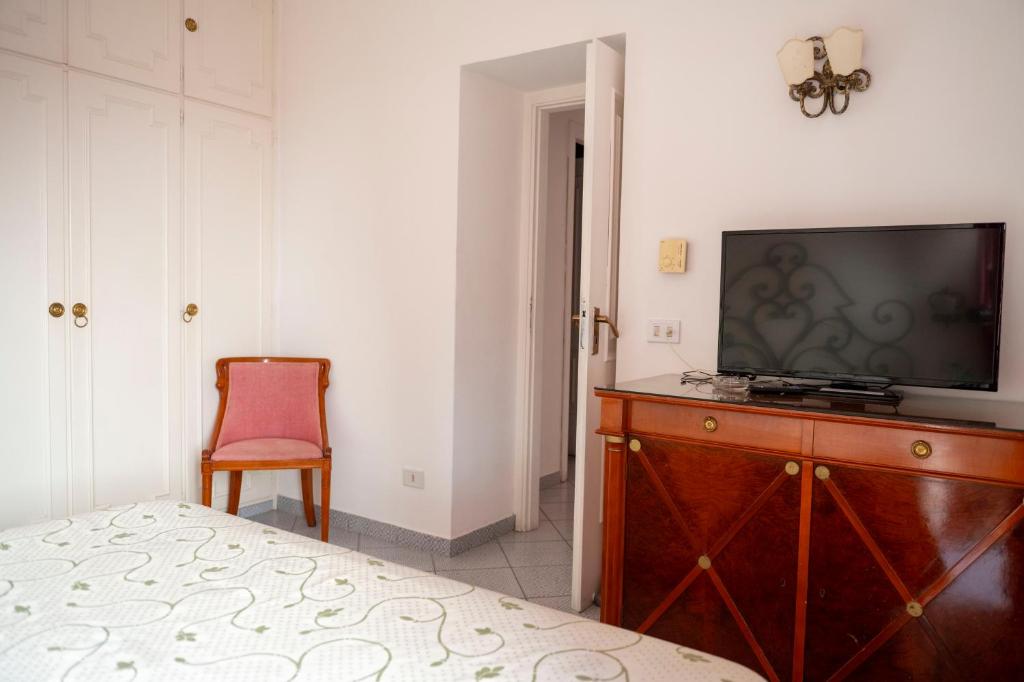 a bedroom with a television on a wooden dresser at Palatium Mari in Capri
