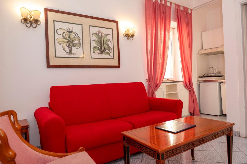 a living room with a red couch and a table at Palatium Mari in Capri