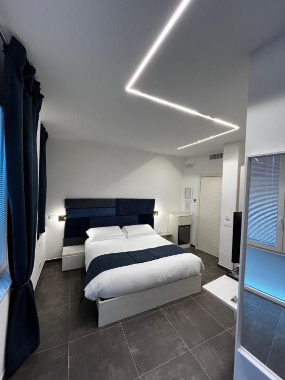 a bedroom with a large bed and a light at Joyfül Accomodation in Finale Ligure