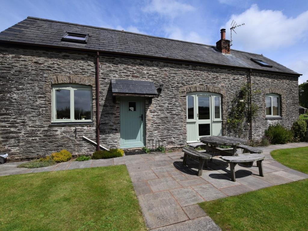 a stone house with a picnic table in front of it at 2 bed in Watchet OLDSO in Wiveliscombe