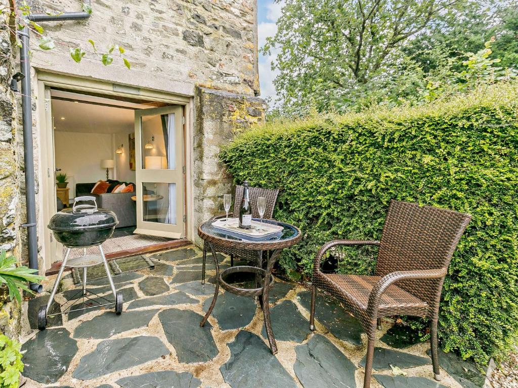 a patio with two chairs and a table at 1 Bed in Tavistock HGARD in Marytavy
