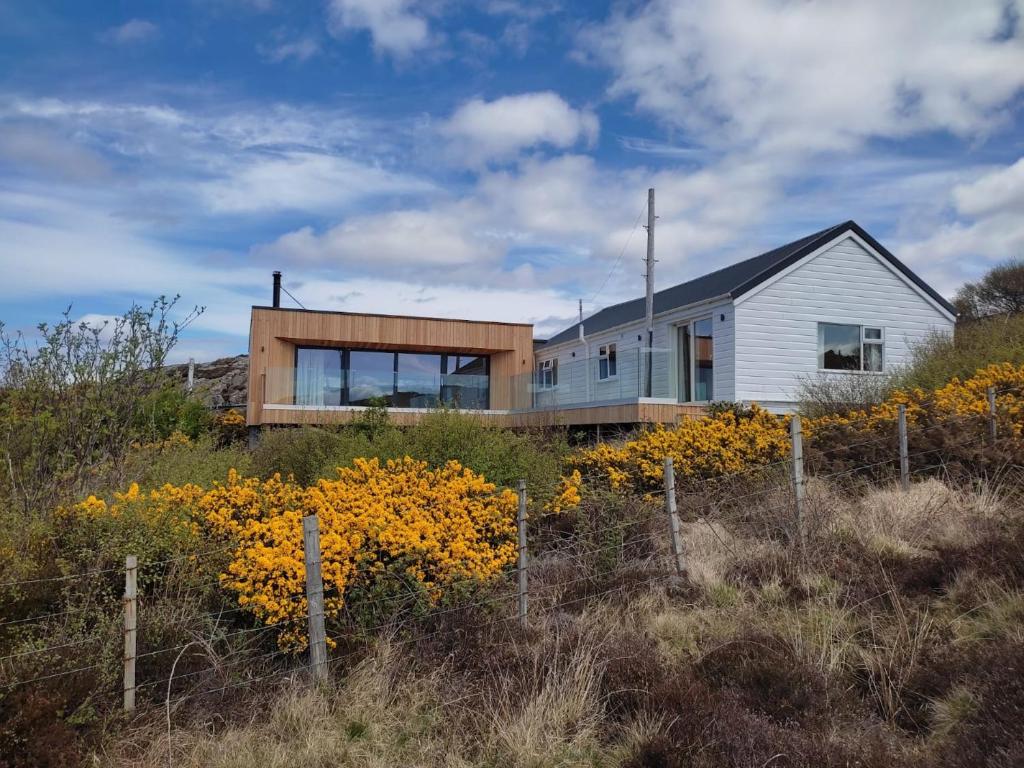 a house on top of a hill with flowers at 3 bed in Scourie SU164 in Rhiconich