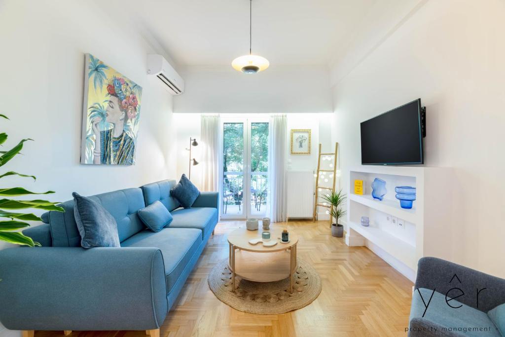 a living room with a blue couch and a tv at Trendy Living in Koukaki! "Hotspot!" Nighttime noise possible in Athens