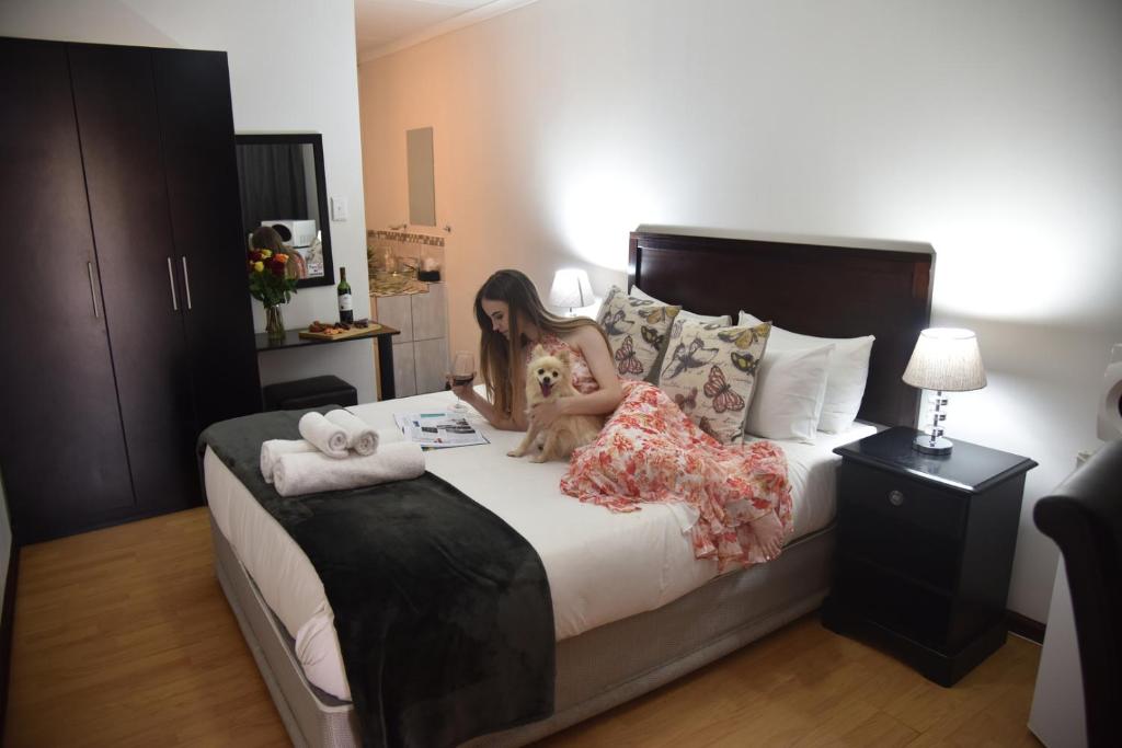 a girl sitting on a bed with a teddy bear at Arvella Guesthouse in Bloemfontein