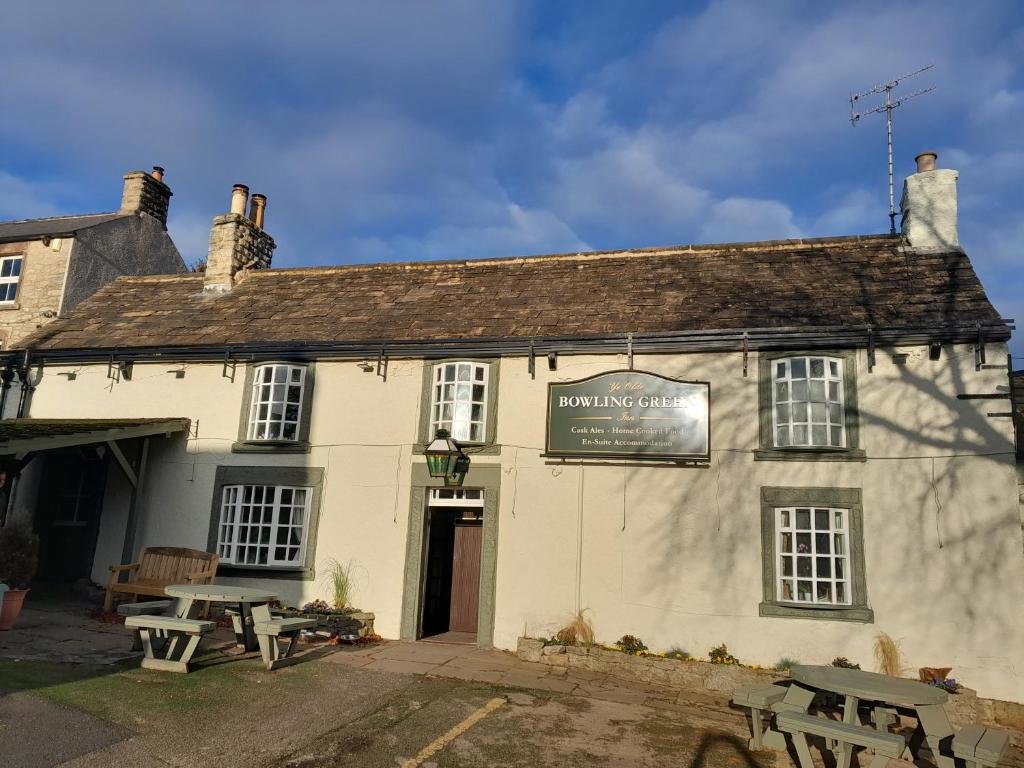 un edificio bianco con tavoli da picnic di fronte di Ye Olde Bowling Green Inn a Bradwell