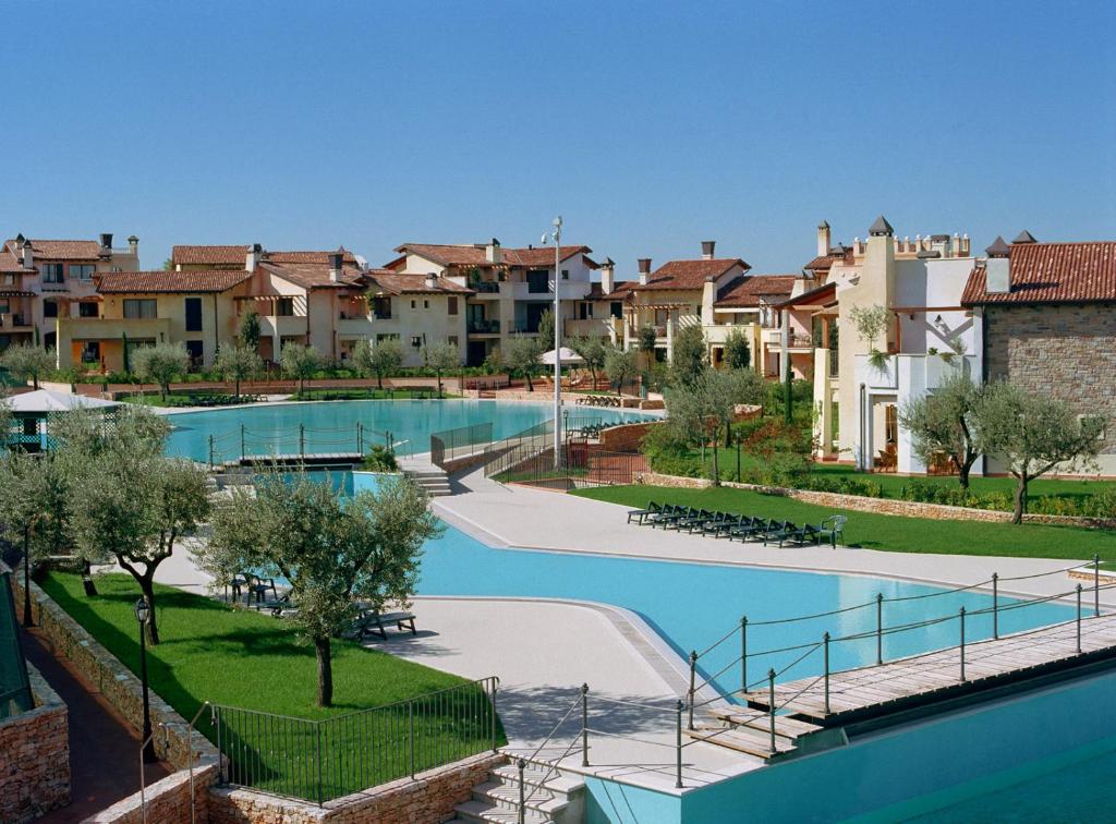 een resort met een zwembad en enkele gebouwen bij Lugana Resort & Sporting Club - Sermana Village in Peschiera del Garda