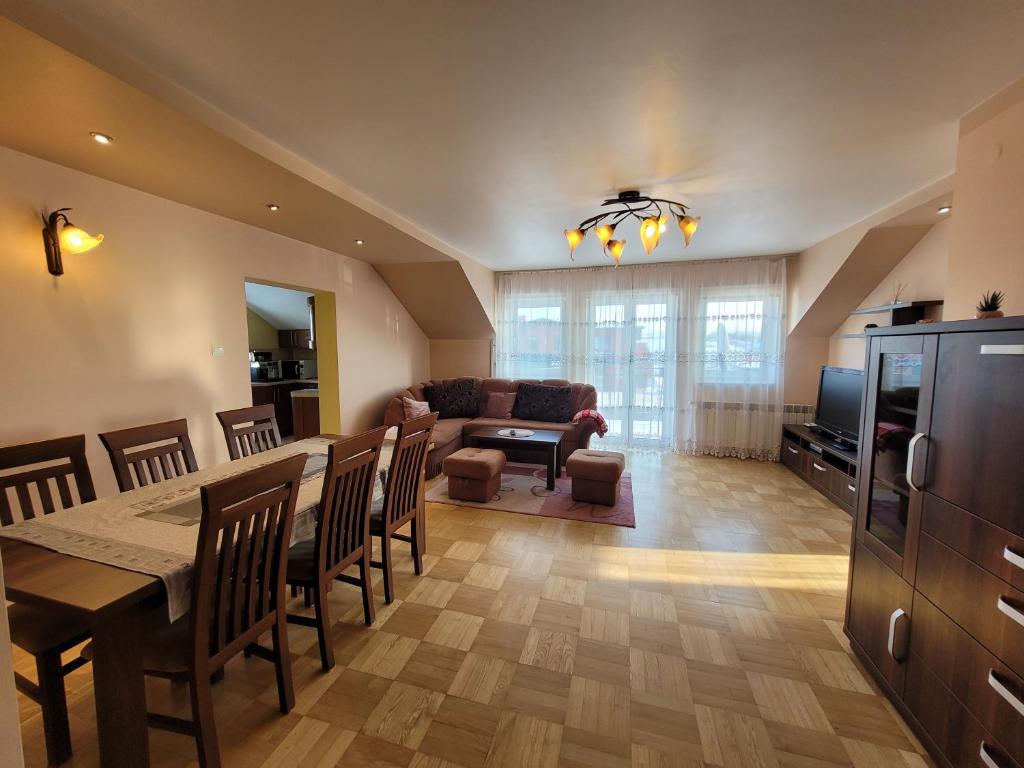 eine Küche und ein Wohnzimmer mit einem Tisch und Stühlen in der Unterkunft Apartament 'Siwy Dom' 