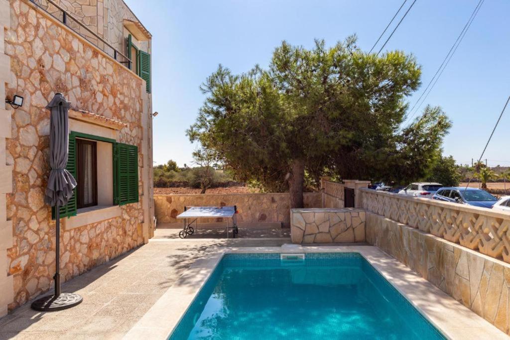a house with a swimming pool next to a building at Villa Sa Llimonera by Slow Villas in Es Llombards