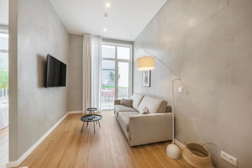 un soggiorno con divano e TV di Lisbon Oriente Apartments by Olala Homes a Lisbona