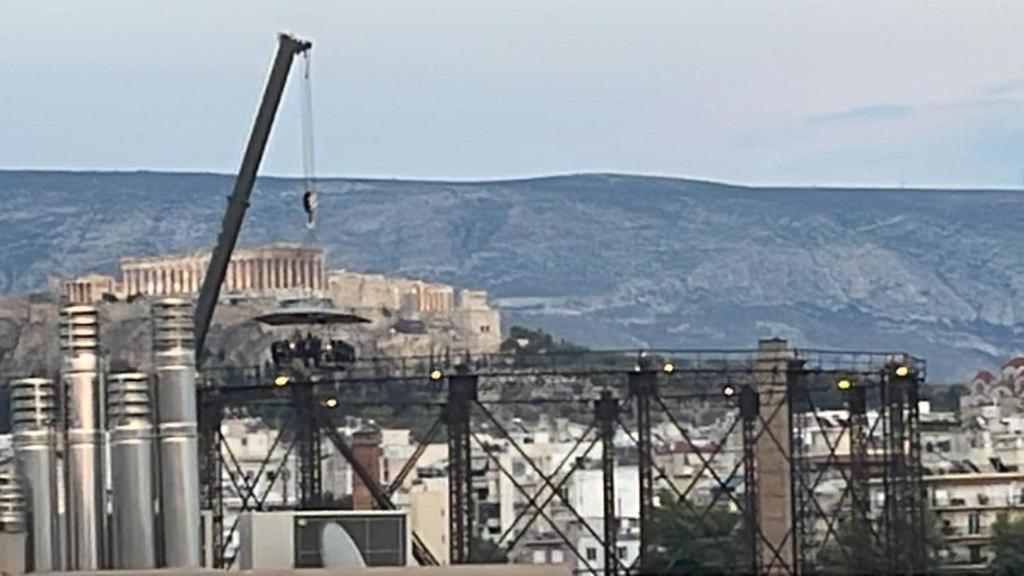 a view of a city with a factory in the background at Rooftop Acropolis Apartment Athens in Athens