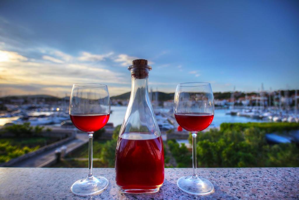 two glasses of red wine sitting on a table at Apartments Irena in Jezera