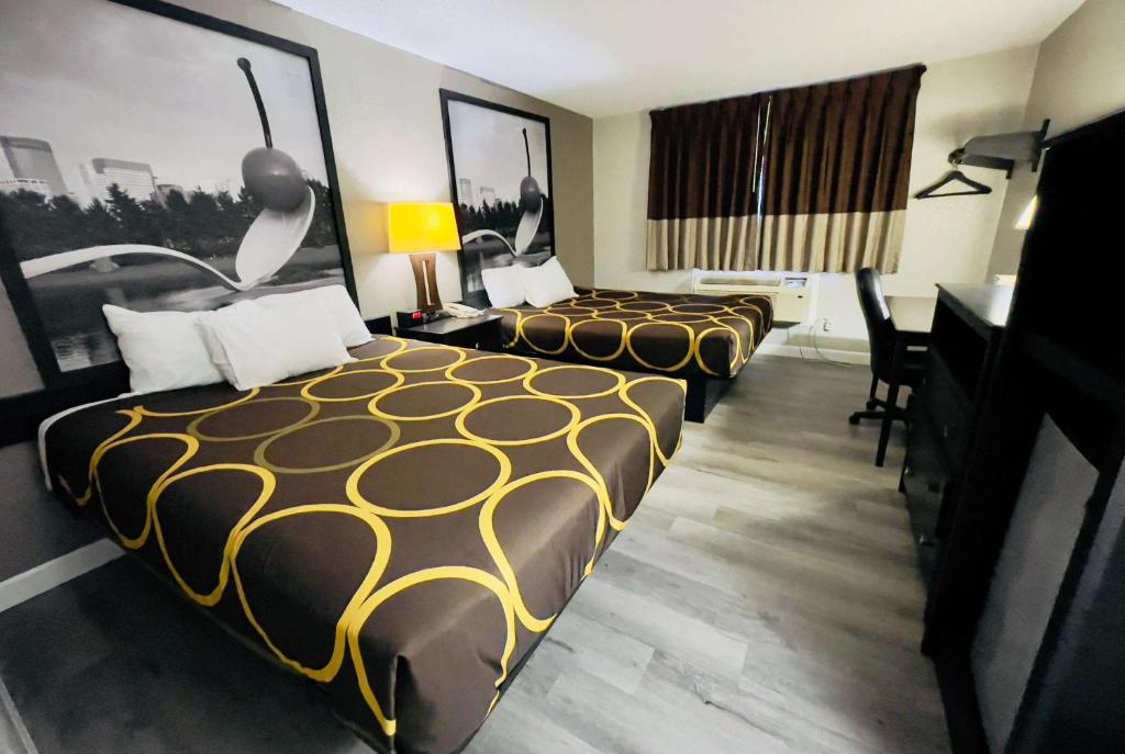 een hotelkamer met 2 bedden en een bureau bij Super 8 by Wyndham Shakopee in Shakopee