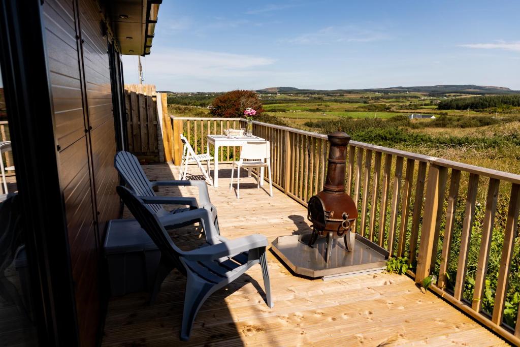 balkon z 2 krzesłami i stołem z widokiem w obiekcie doolinyoga luxury accommodation w mieście Doolin