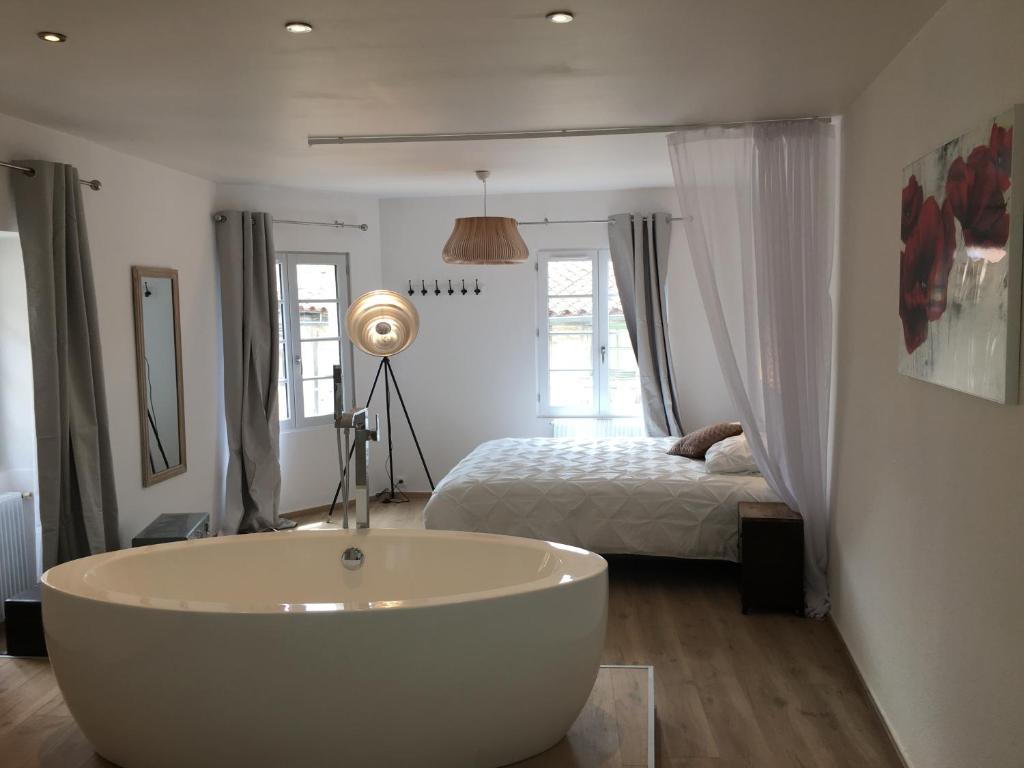 bañera blanca en una habitación con cama en Duplex de charme Laguna - Centre Niort Historique, en Niort