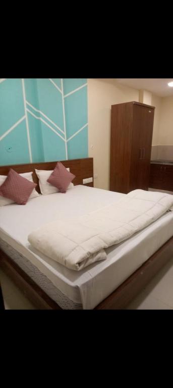 a large bed with white sheets and pillows on it at HoTE 56 indore in Indore