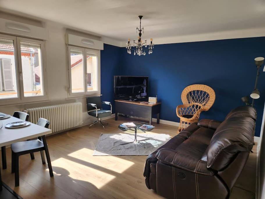 ein Wohnzimmer mit einem Sofa und einem Tisch in der Unterkunft APPT LUMINEUX F3 QUARTIER CALME in Vichy