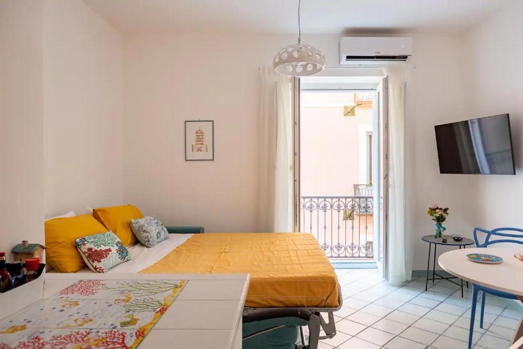 a bedroom with a bed and a table and a tv at Blue Vert Maison - al molo di Gaeta in Gaeta