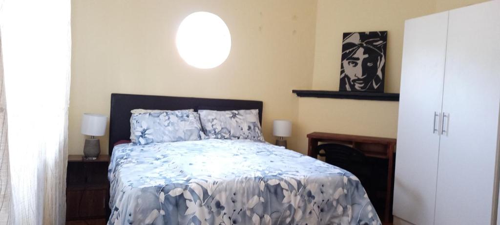 a bedroom with a bed with a blue comforter at Tita comfortable home in Johannesburg