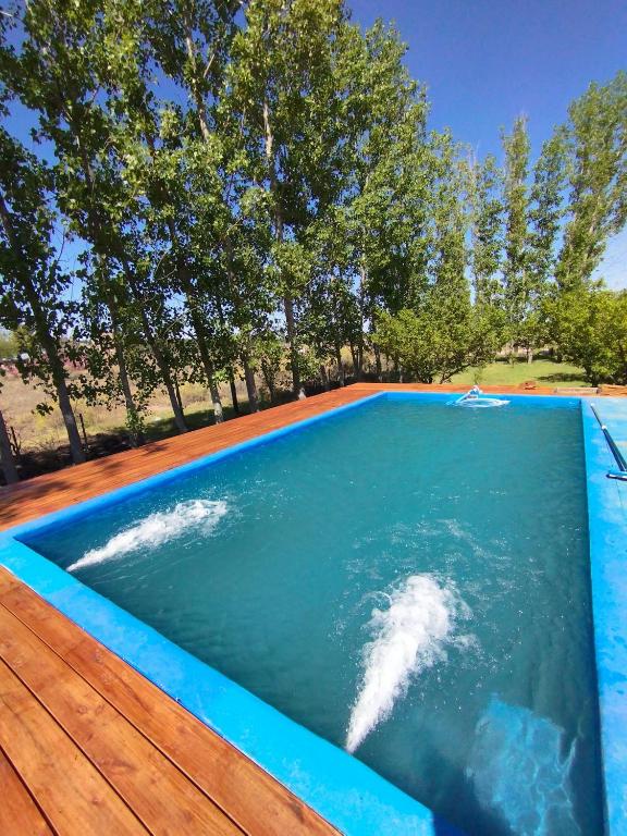 una piscina infinita con terraza de madera y piscina en Casa San Lucas, en San Rafael