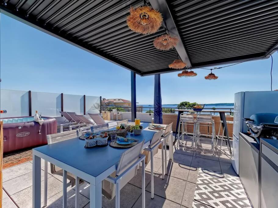 une terrasse avec une table bleue, des chaises et un grill dans l'établissement Superbe toit terrasse vue mer, à Cannes