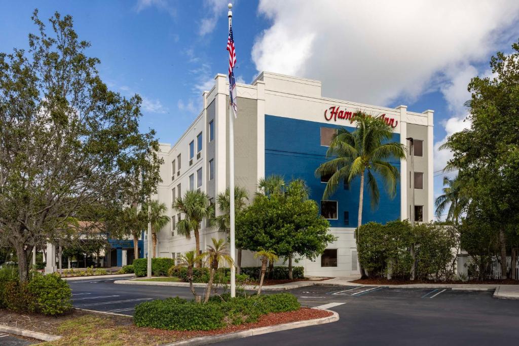 Um edifício com uma bandeira americana em cima. em Hampton Inn West Palm Beach Central Airport em West Palm Beach