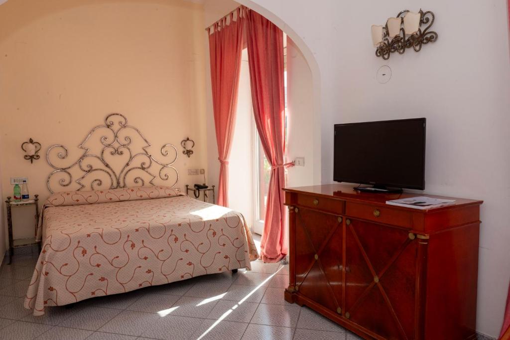 a bedroom with a bed and a flat screen tv at Palatium Mari in Capri