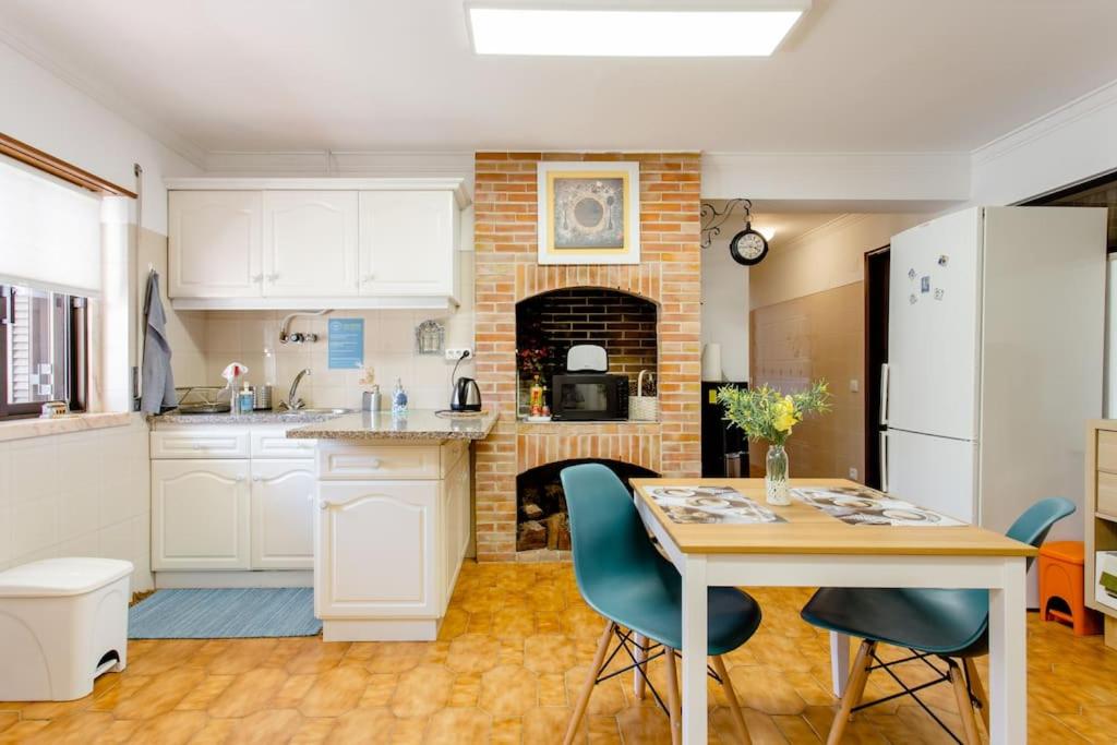 a kitchen with a table and a brick fireplace at Paradise Suites in Carcavelos