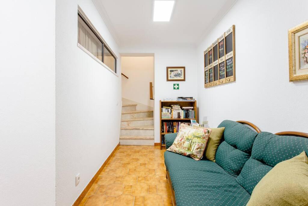 a living room with a blue couch and a staircase at Paradise Suites in Carcavelos