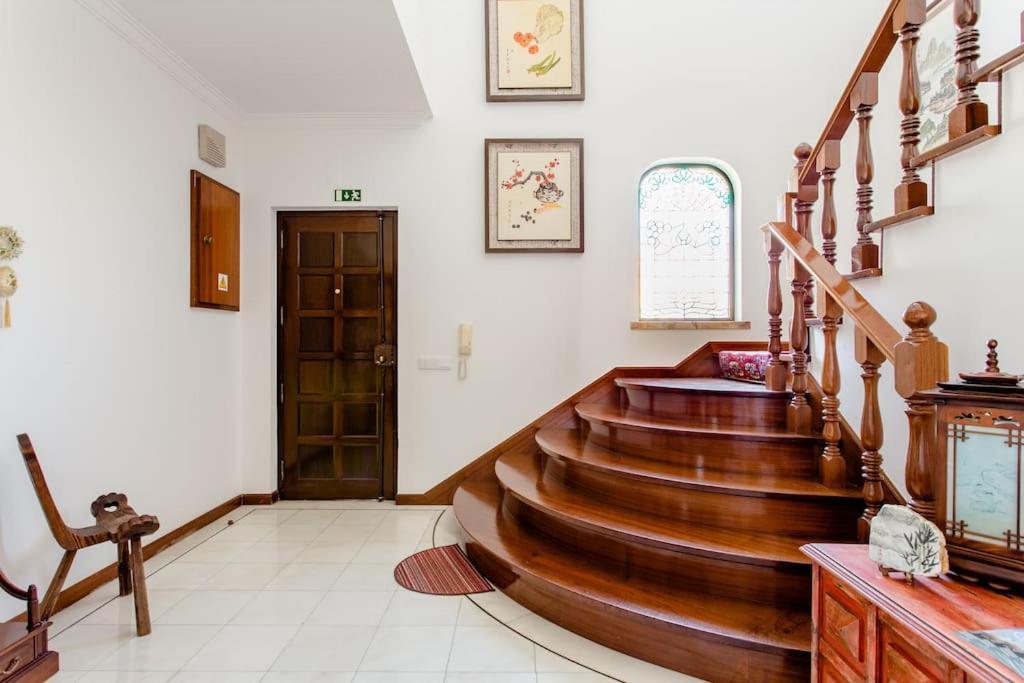 a hallway with a wooden staircase in a house at Paradise Suites in Carcavelos