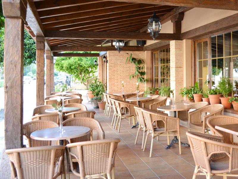 una fila de mesas y sillas en un patio en Hotel Moregón, en Cuacos de Yuste