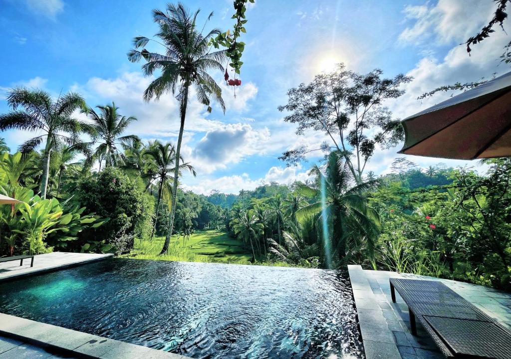 una piscina in un resort con palme di The Papas Villas a Tegalalang
