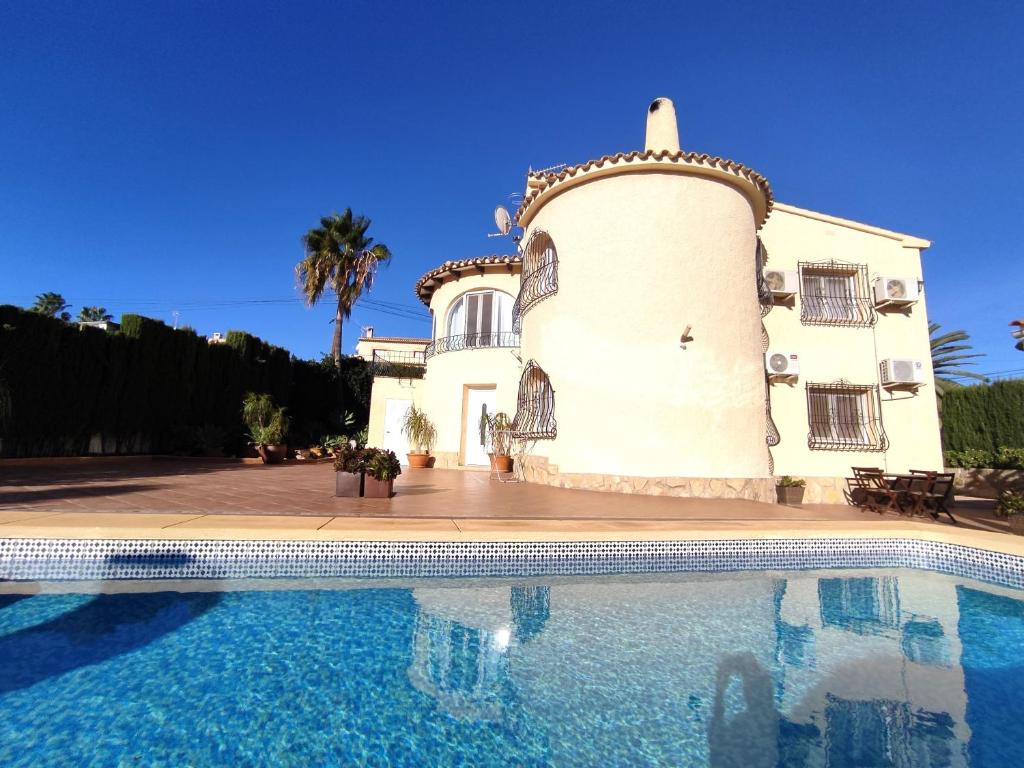 una casa con piscina frente a ella en Casa Luna Llena, en Calpe